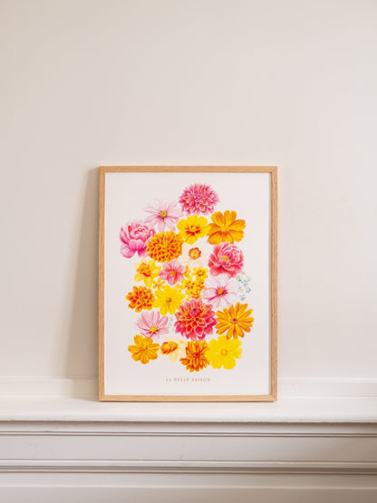 Affiche florale « La Belle Saison », présentée de face dans un cadre en bois clair sur une cheminée blanche.