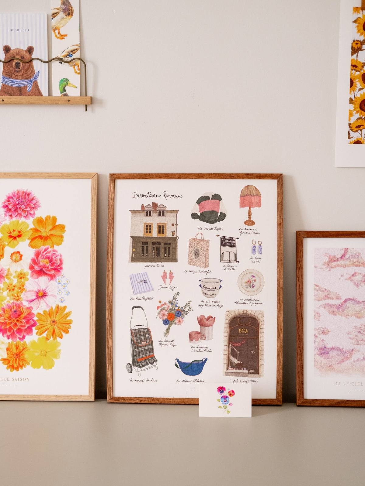 Affiche Inventaire rennais encadrée, présentée avec des affiches illustrées de fleurs, de canard, et d'ours.