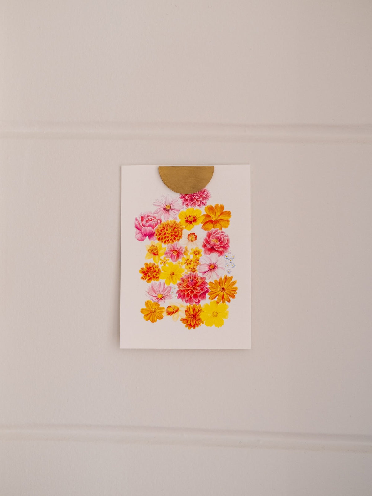 Carte postale illustrée de fleurs roses, jaunes et orange « La Belle Saison », fixée au mur avec une pince dorée.
