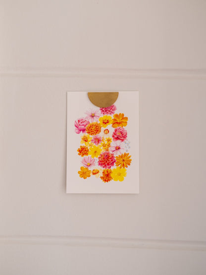 Carte postale illustrée de fleurs roses, jaunes et orange « La Belle Saison », fixée au mur avec une pince dorée.